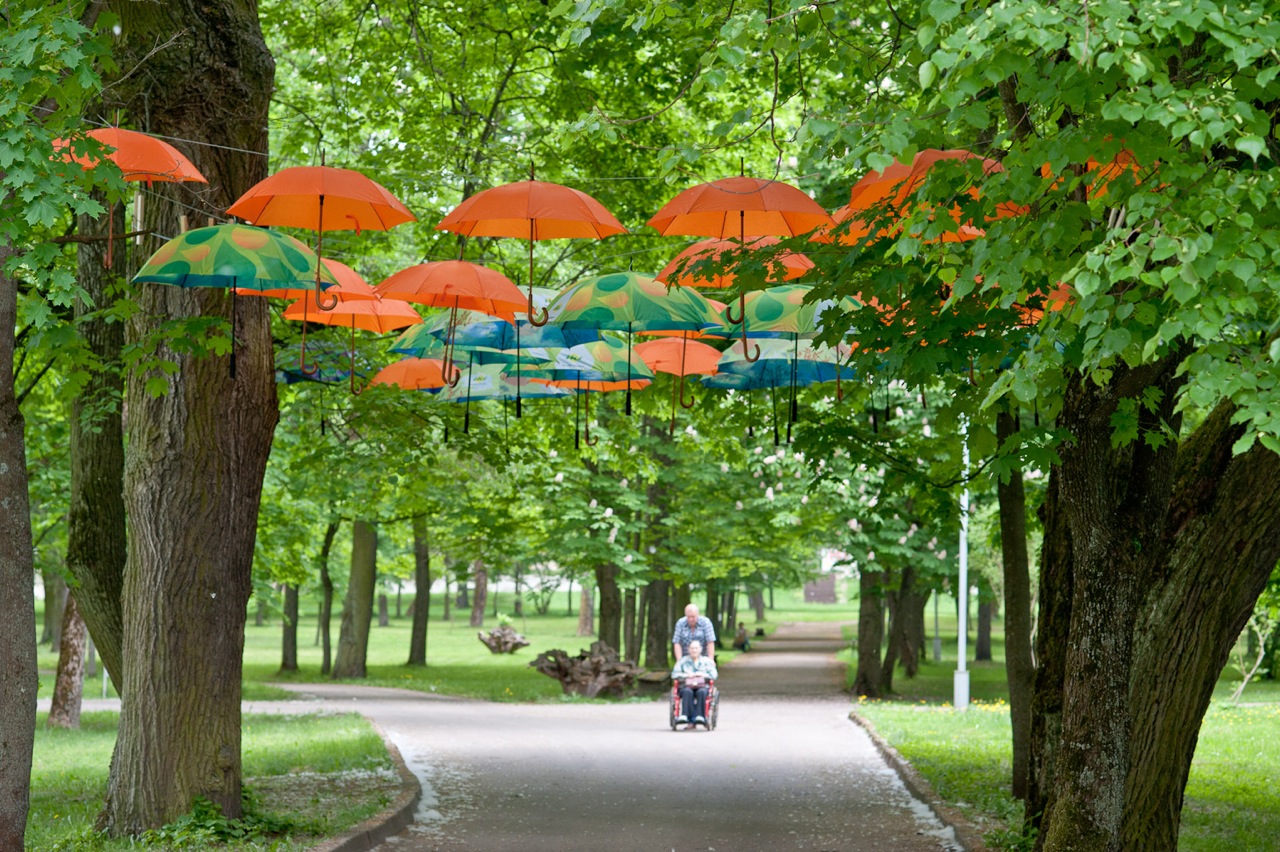 Šv. Roko ligoninės alėja papuošta spalvingų skėčių girlianda   